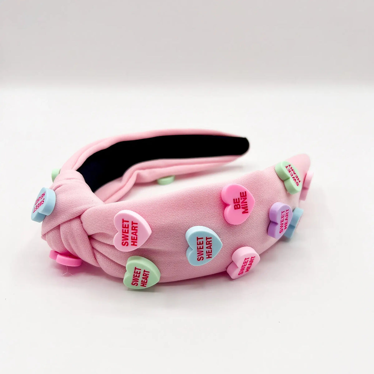 Fashionable headband with sweet pink candy heart accents.