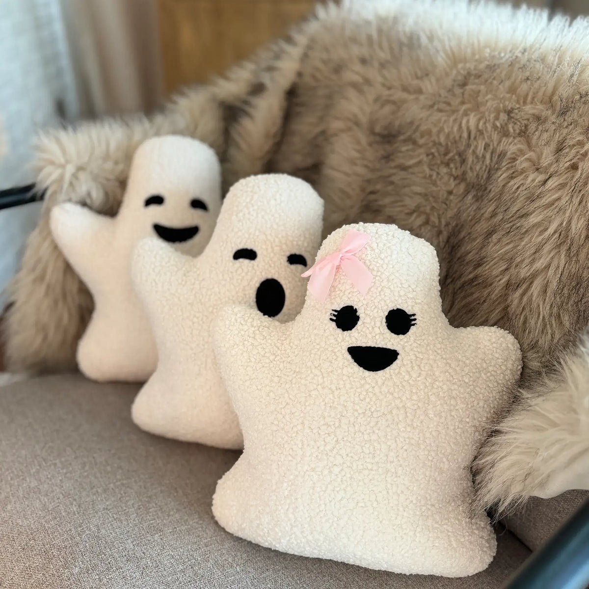 Three different types of ghost pillows sitting on couch