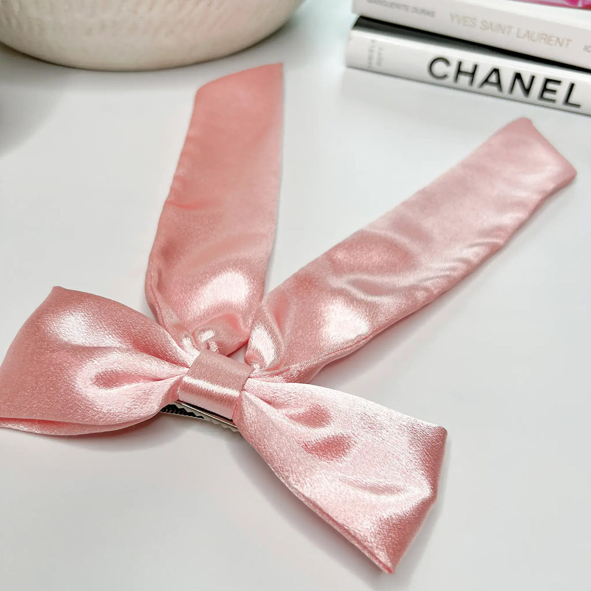 Charming hair accessory: Pink satin hair bow for a touch of feminine elegance