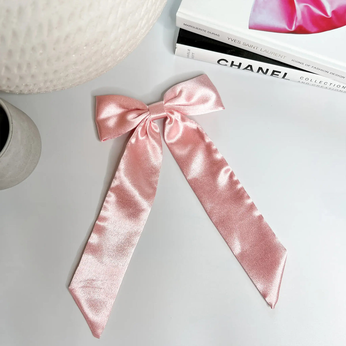 Soft and silky: Pink satin bow, perfect for adding a subtle flair to any look