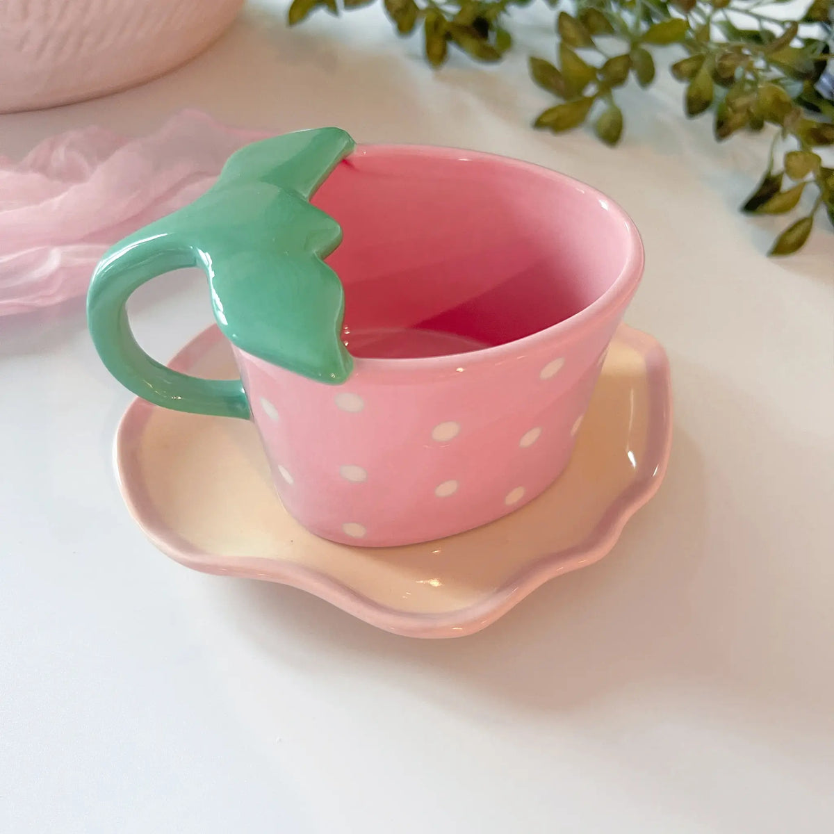 Pink ceramic mug and saucer ensemble featuring delightful strawberry accents