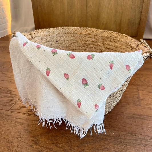 Pink muslin swaddle blanket adorned with sweet strawberries