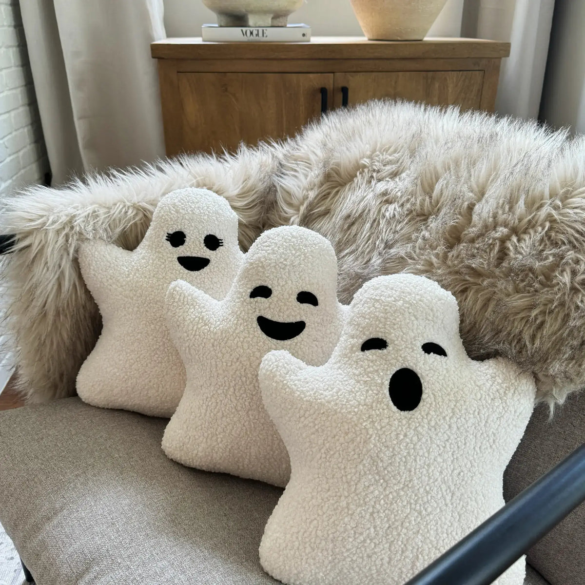 A variety of ghost pillows sitting on couch