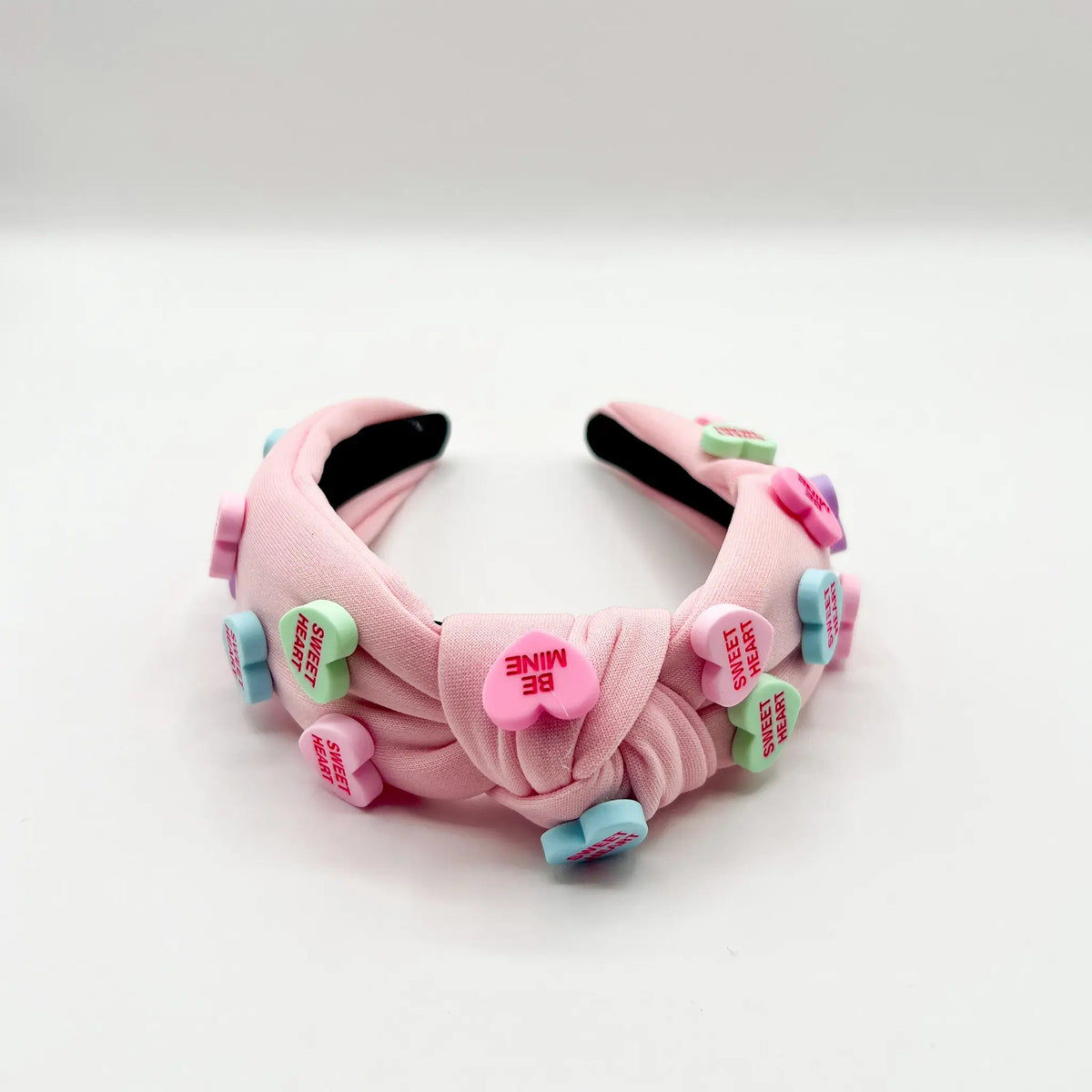 Charming headband adorned with pink candy heart embellishments.
